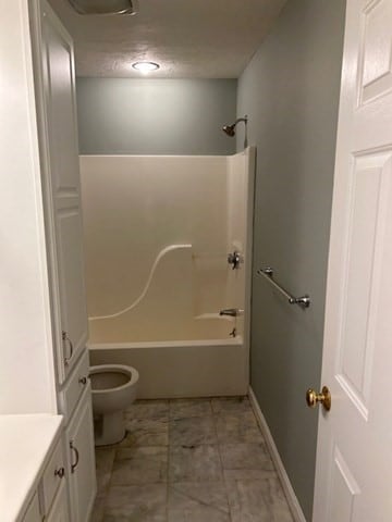 full bathroom with a textured ceiling, vanity, toilet, and tub / shower combination