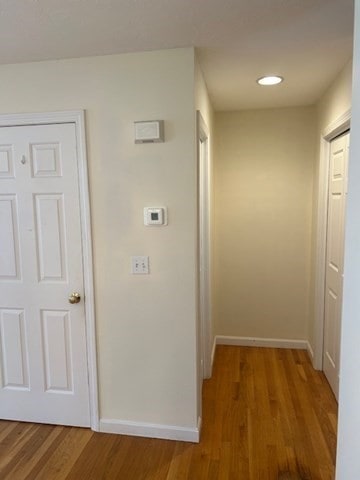 hallway with hardwood / wood-style flooring