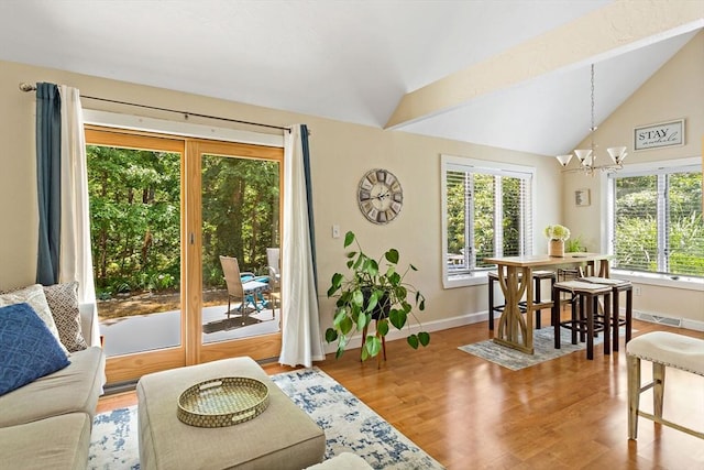 interior space with plenty of natural light, lofted ceiling, and an inviting chandelier