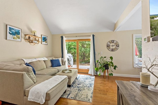 living room with light wood-type flooring and high vaulted ceiling