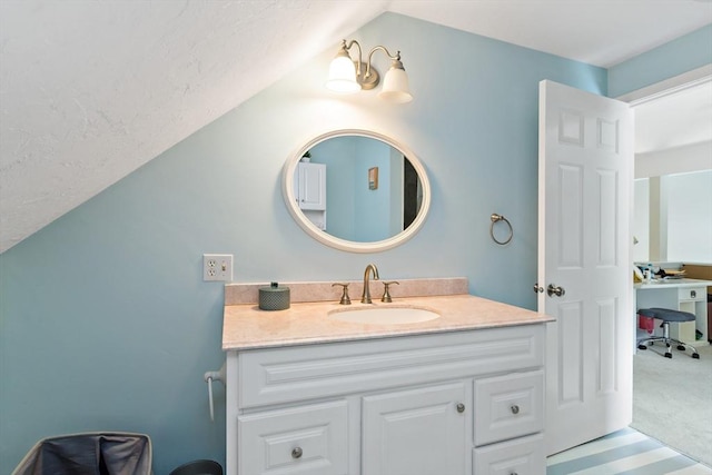 bathroom with vanity and lofted ceiling