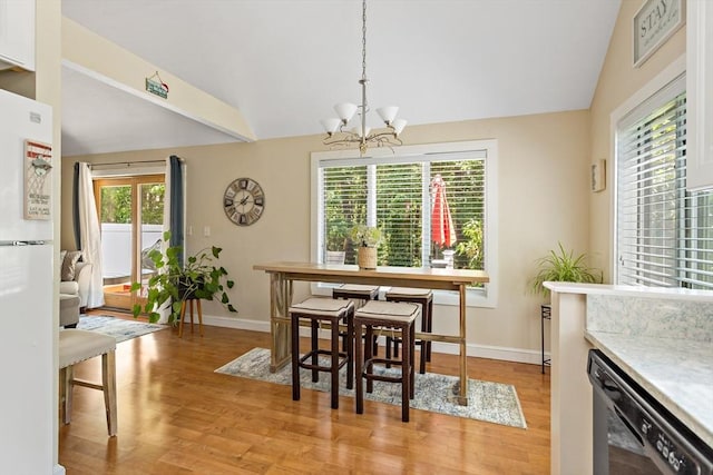 dining area featuring light hardwood / wood-style flooring, plenty of natural light, and a notable chandelier