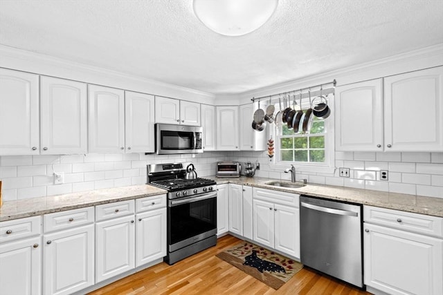 382 Tilden Rd, Scituate, MA 02066 - kitchen featuring appliances with stainless steel finishes, light wood-type flooring, a textured ceiling, and white cabinetry