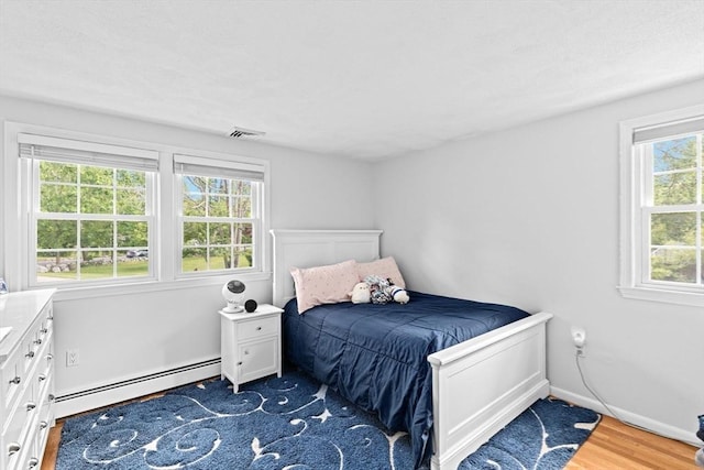 382 Tilden Rd, Scituate, MA 02066 - bedroom with a baseboard heating unit and wood finished floors