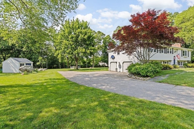 382 Tilden Rd, Scituate, MA 02066 - view of green lawn with an attached garage and asphalt driveway