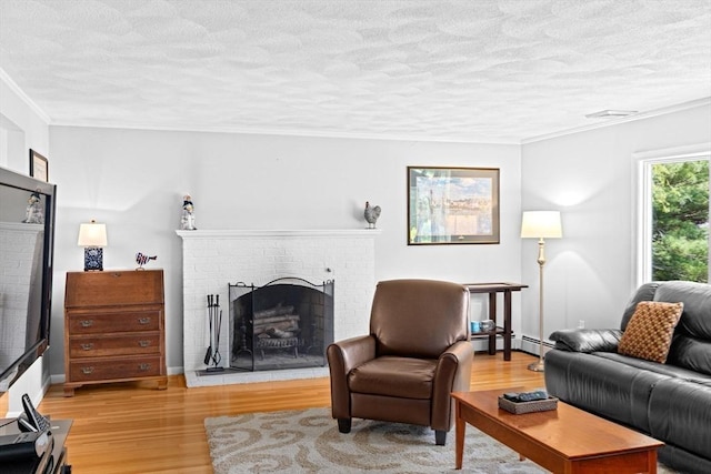 382 Tilden Rd, Scituate, MA 02066 - living area with a fireplace, light wood-style floors, a textured ceiling, and ornamental molding