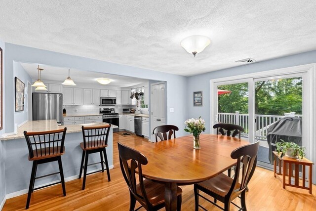 382 Tilden Rd, Scituate, MA 02066 - dining area featuring light wood-type flooring and a textured ceiling