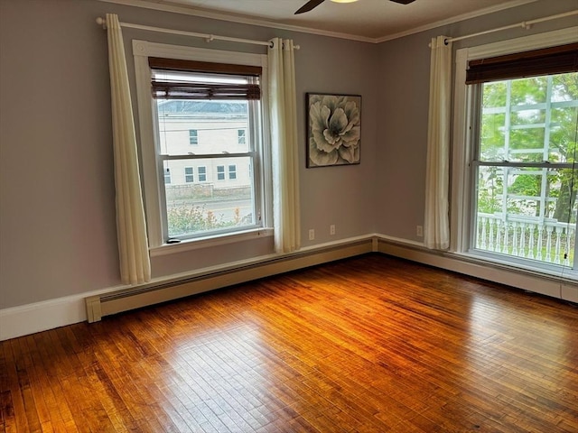 spare room featuring healthy amount of natural light, crown molding, a ceiling fan, and wood finished floors