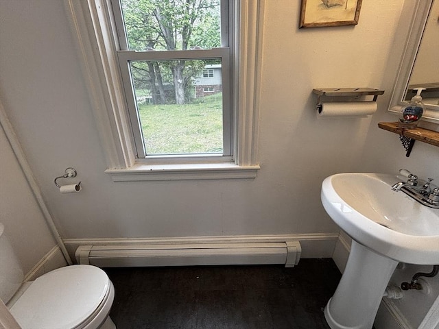bathroom featuring healthy amount of natural light, toilet, and baseboards