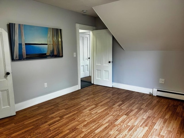 bonus room with wood finished floors, baseboards, a baseboard heating unit, and lofted ceiling