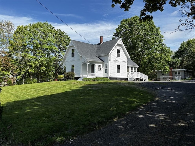 view of home's exterior featuring a chimney, a yard, and roof with shingles
