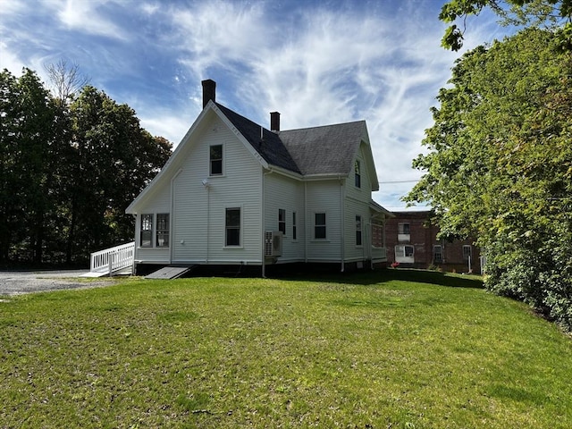 back of property with a chimney, a yard, and a cooling unit