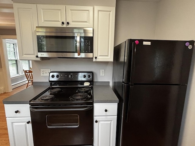 kitchen with black appliances, dark countertops, white cabinetry, and wood finished floors