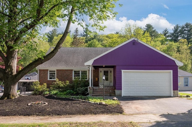58 Spring St, Wakefield, MA 01880 - view of front of property featuring driveway, a garage, brick siding, and roof with shingles