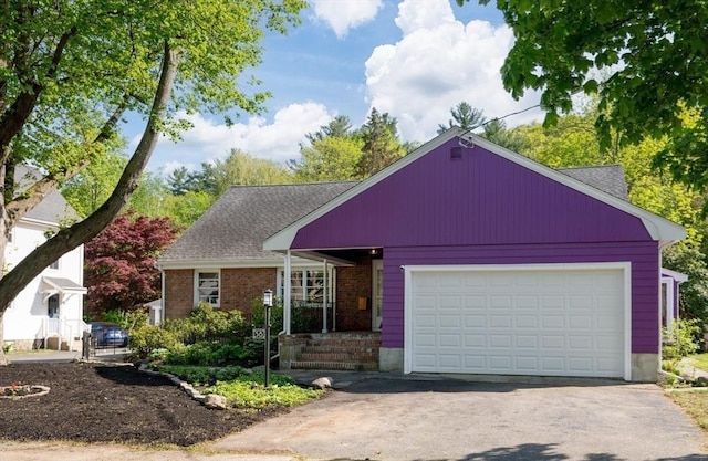 58 Spring St, Wakefield, MA 01880 - view of front of house with asphalt driveway, a garage, brick siding, and a shingled roof