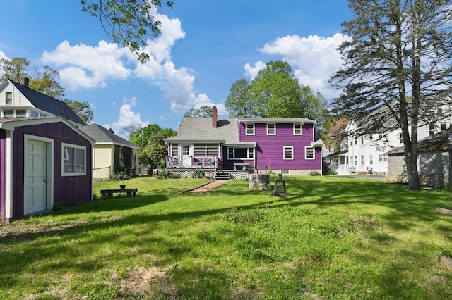 58 Spring St, Wakefield, MA 01880 - rear view of property with a chimney, a lawn, an outbuilding, and a wooden deck