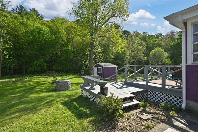 58 Spring St, Wakefield, MA 01880 - view of grassy yard with a storage unit, a wooden deck, an outbuilding, and a wooded view