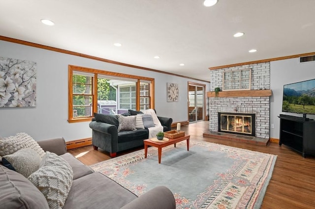 58 Spring St, Wakefield, MA 01880 - living room featuring crown molding, baseboard heating, recessed lighting, a brick fireplace, and baseboards