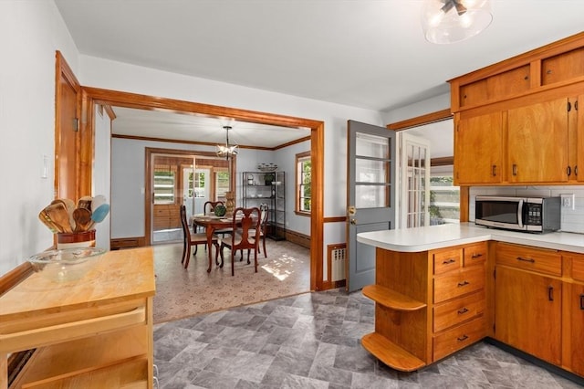 58 Spring St, Wakefield, MA 01880 - kitchen with stainless steel microwave, open shelves, light countertops, crown molding, and baseboards
