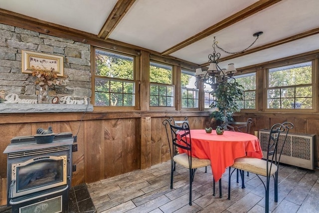 7 Mount Dustin Ave, Haverhill, MA 01832 - dining area with radiator heating unit, a chandelier, beam ceiling, a wood stove, and wood finished floors