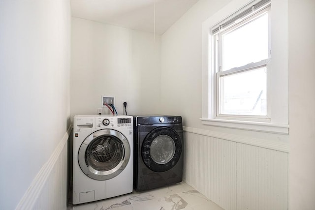 laundry area with a wainscoted wall, marble finish floor, independent washer and dryer, plenty of natural light, and laundry area