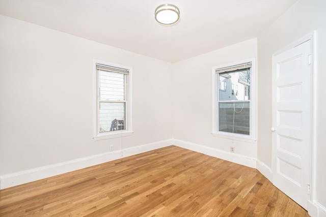 unfurnished room featuring baseboards and light wood-style floors