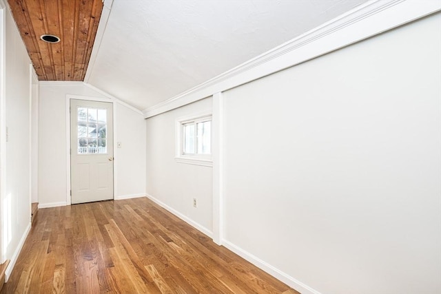 interior space with vaulted ceiling, baseboards, and wood finished floors