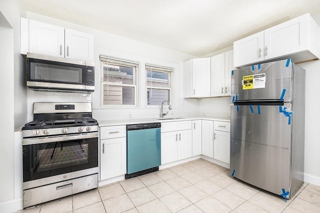 kitchen with white cabinetry, light countertops, appliances with stainless steel finishes, and a sink