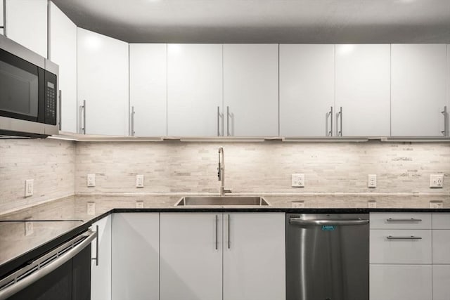 51 Warren St Unit 2-2, Waltham, MA 02453 - kitchen with white cabinetry, tasteful backsplash, appliances with stainless steel finishes, and a sink