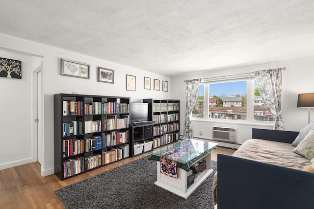 51 Warren St Unit 2-2, Waltham, MA 02453 - living area featuring baseboards, a wall mounted AC, a textured ceiling, and hardwood / wood-style flooring