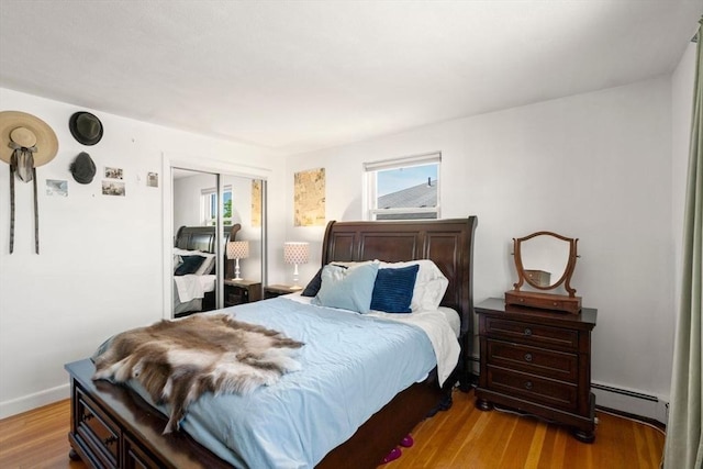 51 Warren St Unit 2-2, Waltham, MA 02453 - bedroom with a closet, baseboard heating, and wood finished floors