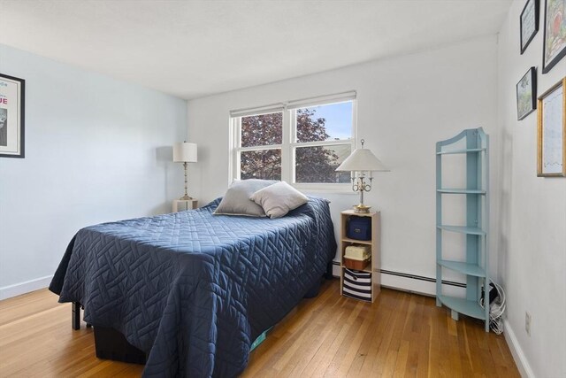 51 Warren St Unit 2-2, Waltham, MA 02453 - bedroom with baseboards, baseboard heating, and wood-type flooring