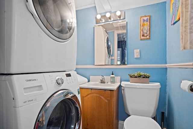 bathroom with vanity, stacked washing maching and dryer, and toilet