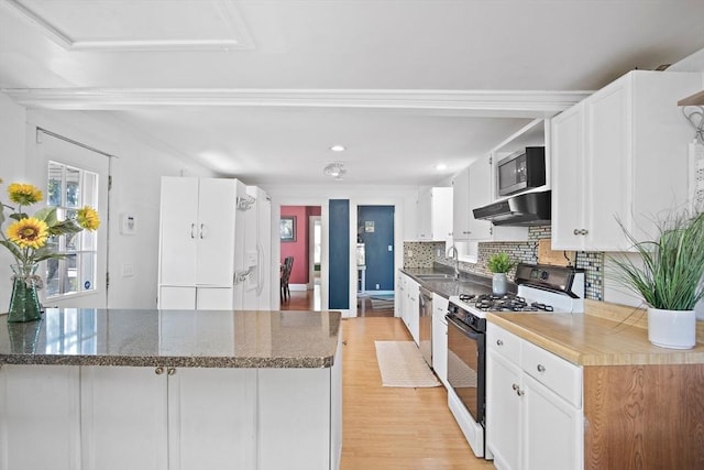 kitchen with gas range, light wood-type flooring, a sink, under cabinet range hood, and white cabinetry