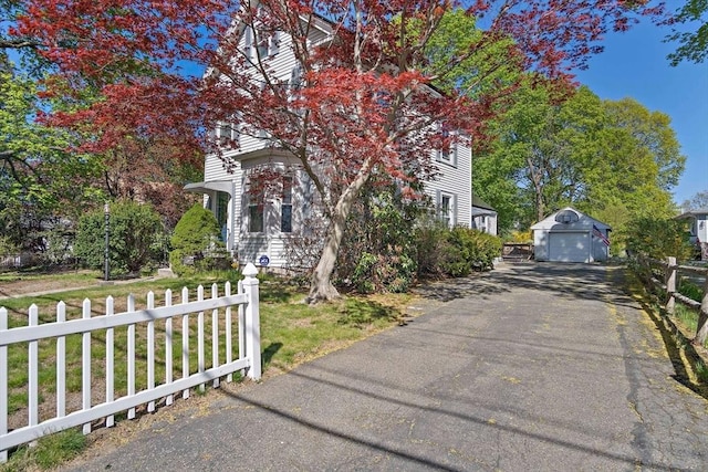 61 Mishawum Rd, Woburn, MA 01801 - view of front of house with a garage, asphalt driveway, fence, and an outdoor structure