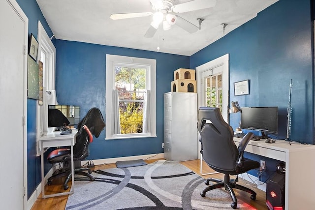 office featuring a ceiling fan, baseboards, and wood finished floors