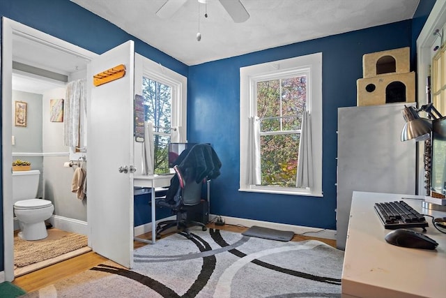 office space with baseboards, a ceiling fan, and wood finished floors