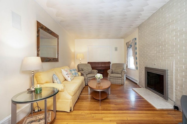 33 Samoset Ave, Quincy, MA 02169 - living room featuring a baseboard radiator, wood finished floors, a brick fireplace, and baseboards