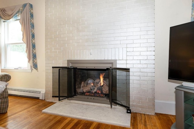 33 Samoset Ave, Quincy, MA 02169 - detailed view of a baseboard radiator, a lit fireplace, wood finished floors, and baseboards