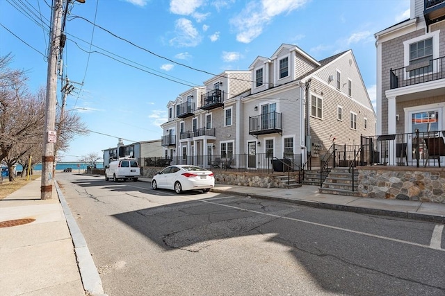 view of road featuring a residential view, curbs, street lighting, and sidewalks