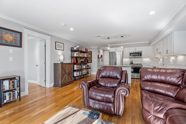 living room featuring baseboards, crown molding, and light wood finished floors