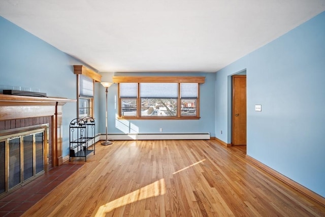 unfurnished living room featuring hardwood / wood-style floors, a fireplace, and baseboard heating