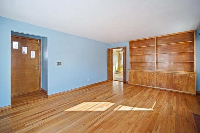 unfurnished bedroom with light hardwood / wood-style flooring, a closet, and a baseboard radiator