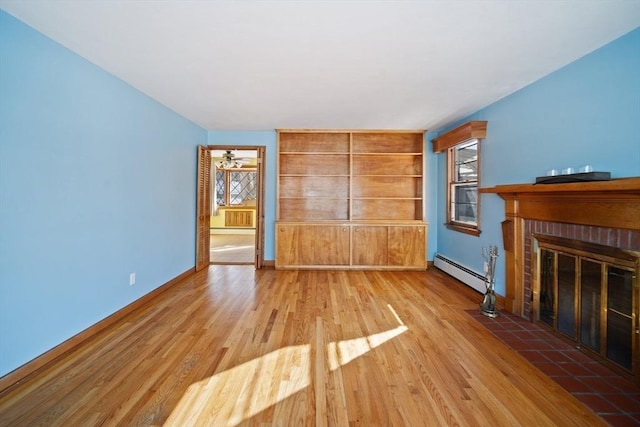 unfurnished living room featuring hardwood / wood-style floors, a fireplace, baseboard heating, and built in shelves