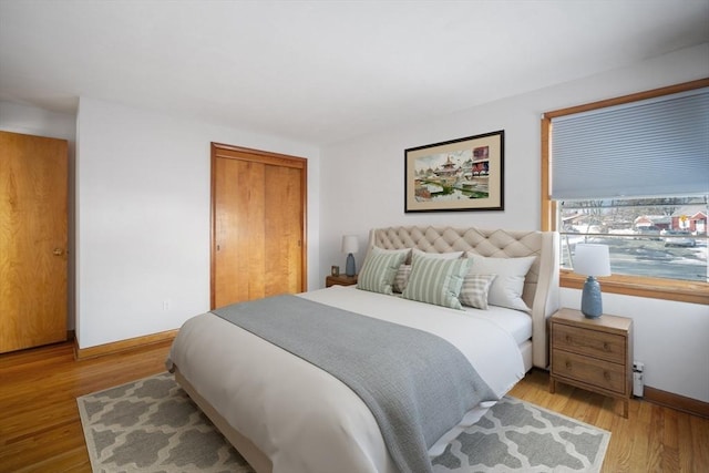 bedroom with light hardwood / wood-style flooring and a closet