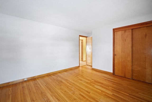 unfurnished bedroom featuring light hardwood / wood-style floors and a closet