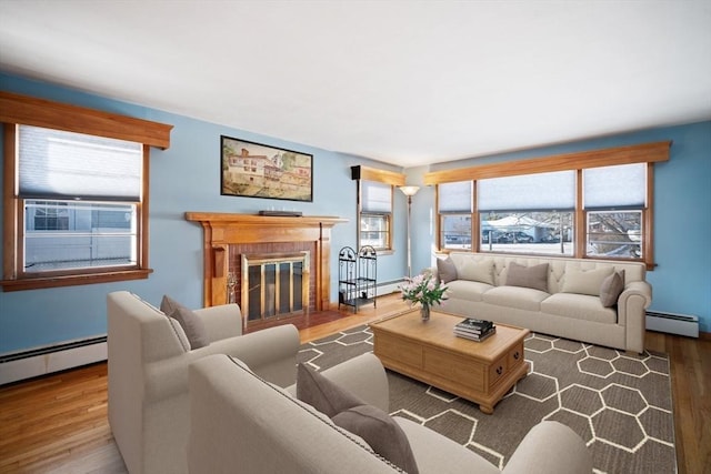 living room with hardwood / wood-style flooring, a fireplace, and baseboard heating