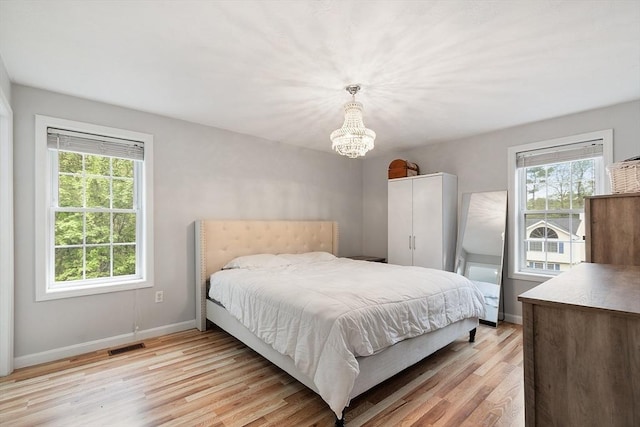 2 Pinebrook Ln, Worcester, MA 01609 - bedroom with multiple windows, a chandelier, light wood finished floors, and baseboards