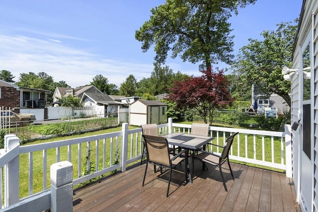 20 King St, Wilmington, MA 01887 - wooden terrace featuring outdoor dining area, a storage unit, and a residential view