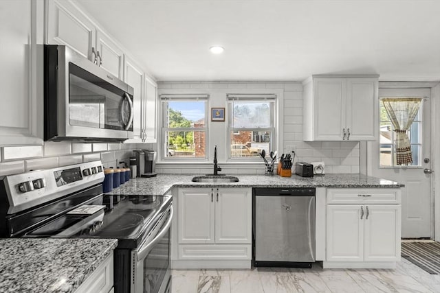20 King St, Wilmington, MA 01887 - kitchen with stainless steel appliances, white cabinets, decorative backsplash, light marble finish flooring, and light stone countertops